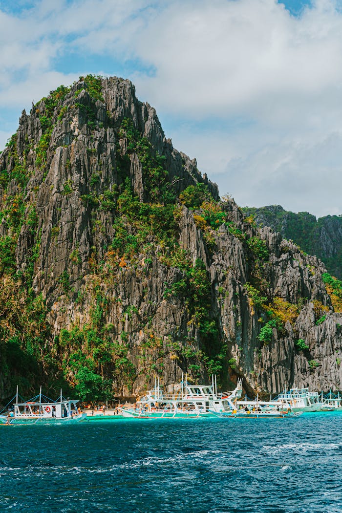 services-04 Stunning limestone cliffs and boats in El Nido, Palawan, Philippines, showcasing natural beauty.