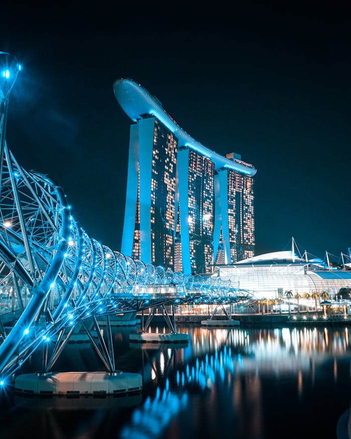 A breathtaking night shot of Marina Bay Sands and Helix Bridge with reflections in Singapore.